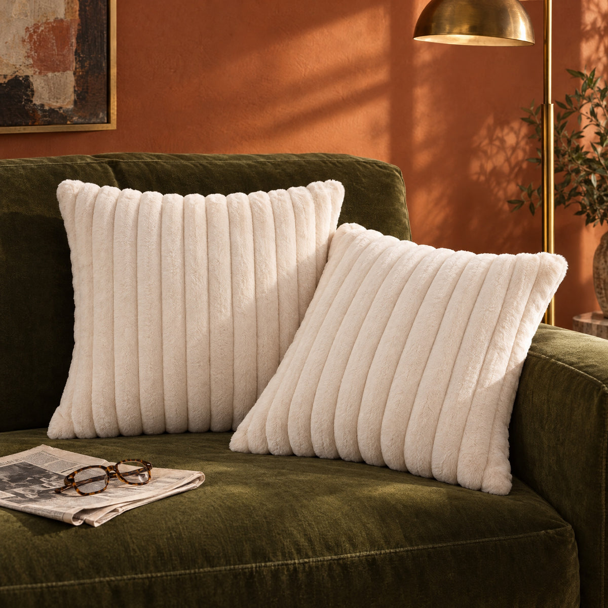 Two Dune ribbed cushions on an olive green velvet sofa