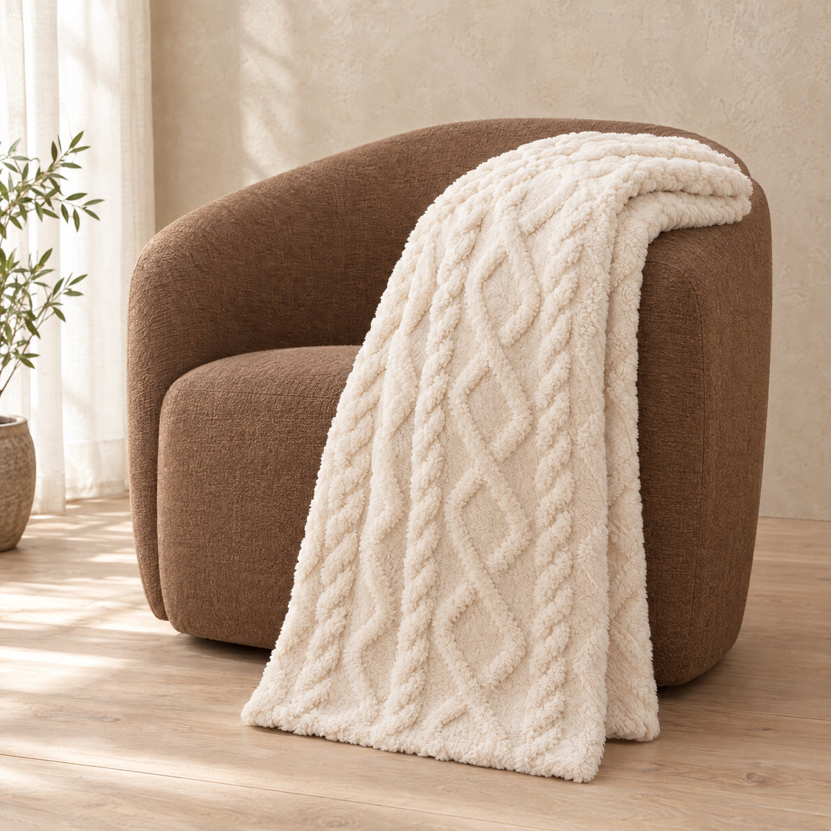 Loft Cable Plush Throw over the arm of a brown armchair