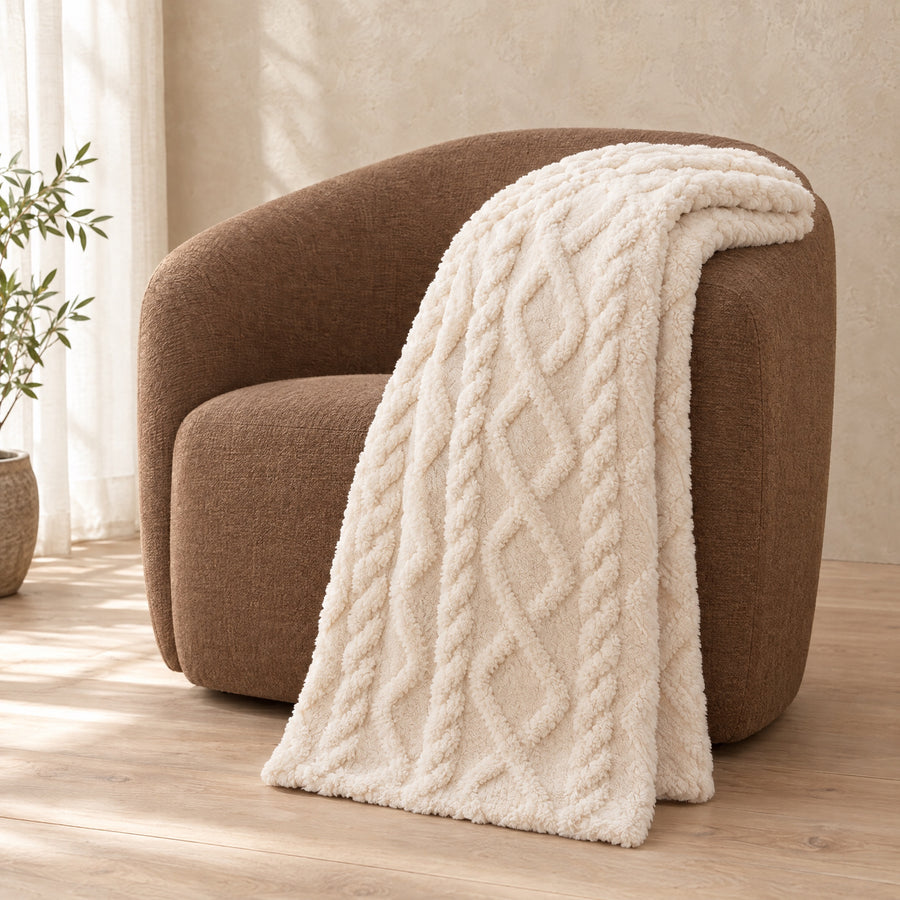 Loft Cable Plush Throw over the arm of a brown armchair